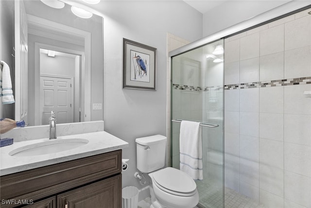 bathroom featuring toilet, vanity, and walk in shower