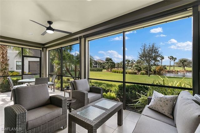 sunroom / solarium with ceiling fan and a water view