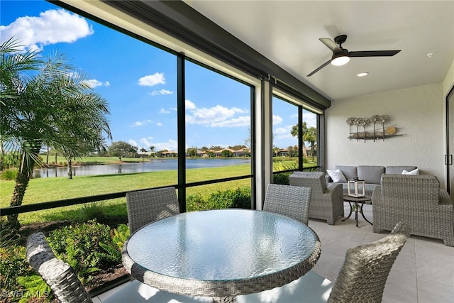 sunroom featuring a water view and a ceiling fan