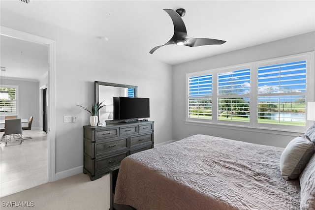 bedroom featuring light carpet, ceiling fan, and crown molding