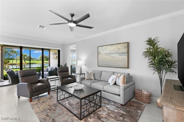 tiled living area featuring crown molding, visible vents, a ceiling fan, and a water view