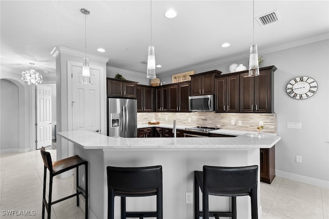 kitchen featuring pendant lighting, a kitchen breakfast bar, decorative backsplash, and stainless steel appliances