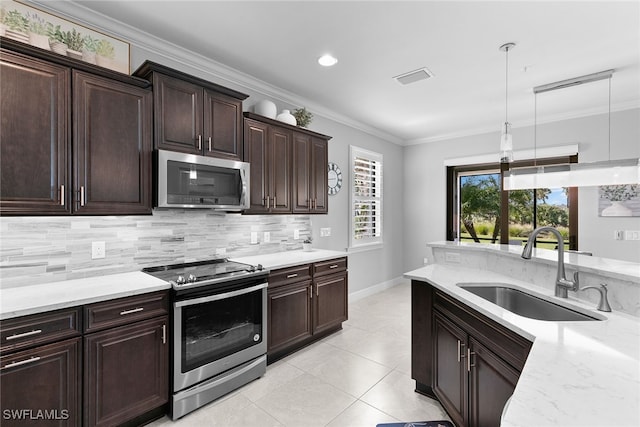 kitchen with decorative backsplash, ornamental molding, stainless steel appliances, sink, and decorative light fixtures