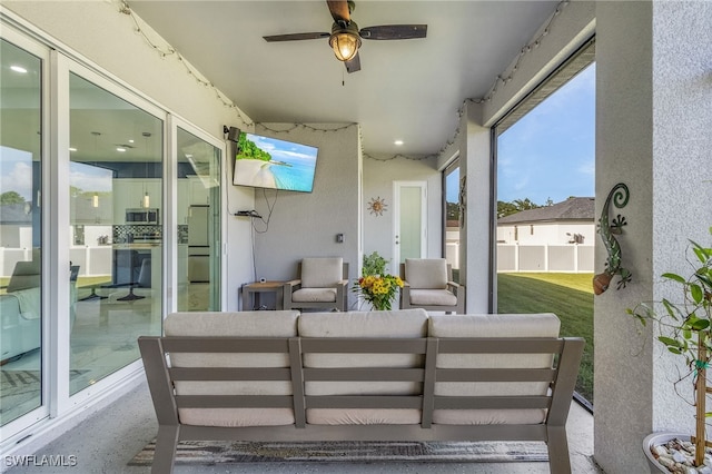 sunroom / solarium featuring ceiling fan