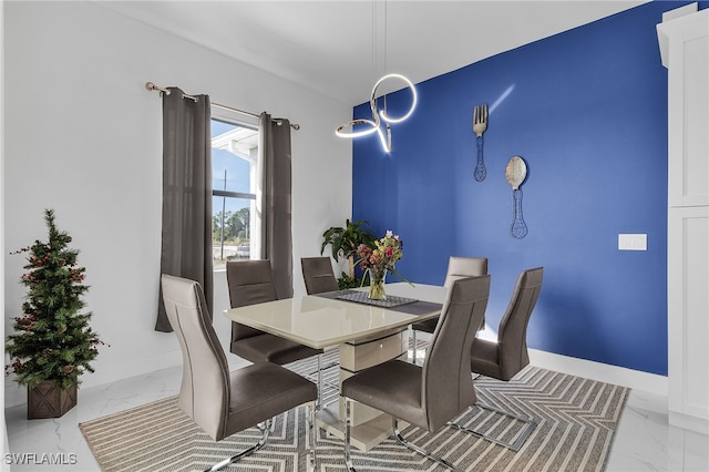 dining room featuring a notable chandelier, baseboards, and marble finish floor