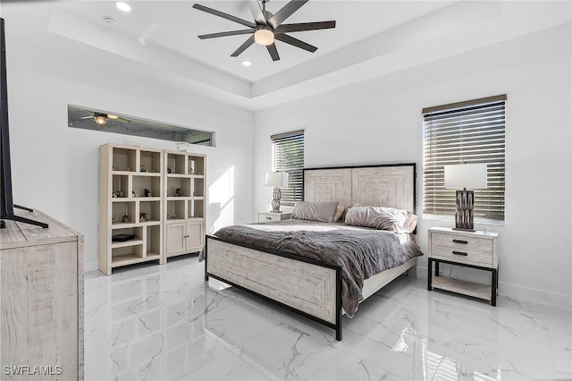 bedroom featuring a raised ceiling and ceiling fan