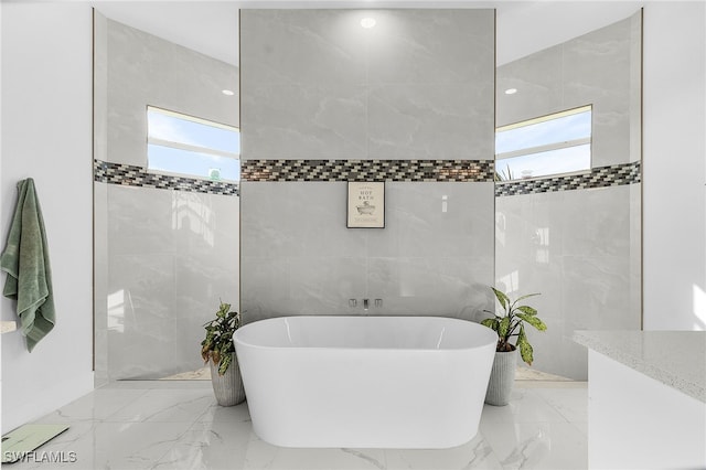 bathroom with a bath and tile walls