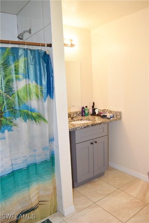 bathroom with vanity, curtained shower, and tile patterned floors