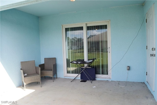 view of exterior entry with a patio