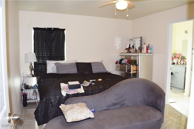 bedroom featuring ceiling fan, light tile patterned floors, and ensuite bath