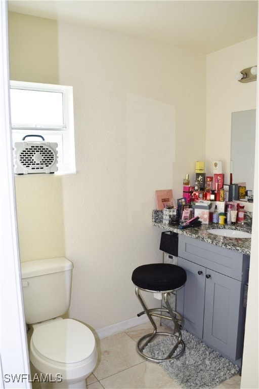 bathroom with tile patterned flooring, vanity, and toilet