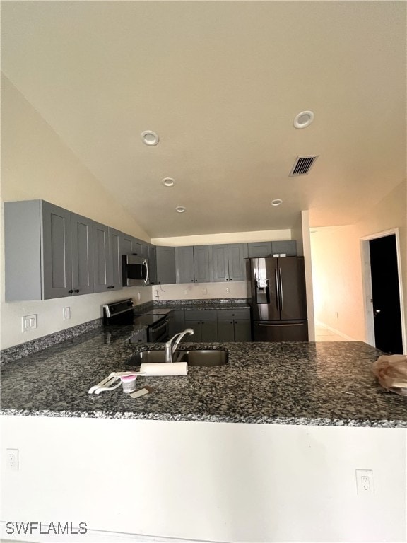 kitchen featuring sink, black electric range oven, dark stone countertops, kitchen peninsula, and fridge with ice dispenser