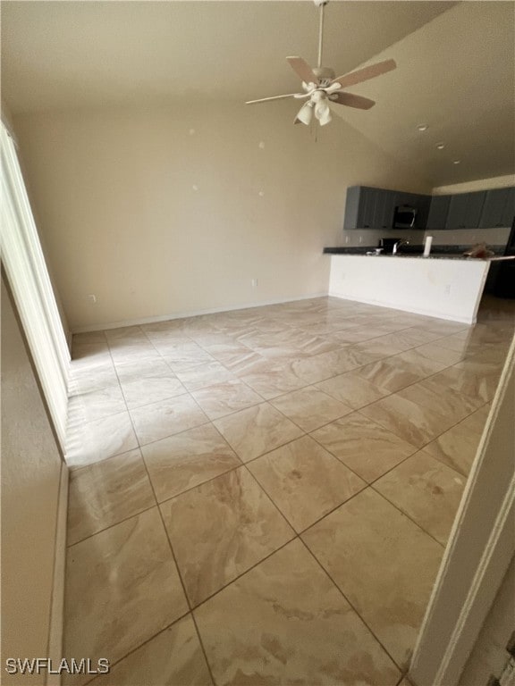 unfurnished living room featuring vaulted ceiling and ceiling fan