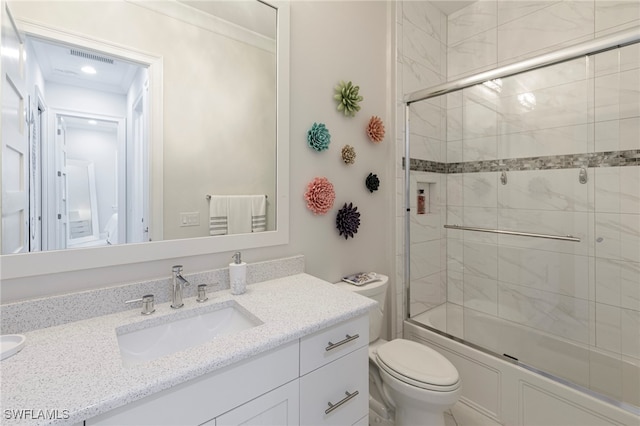 full bathroom with shower / bath combination with glass door, vanity, and toilet