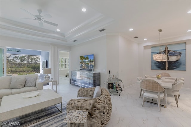 living room featuring ceiling fan, a raised ceiling, and ornamental molding