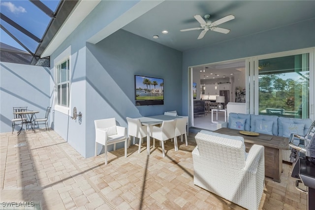 view of patio featuring an outdoor living space, ceiling fan, and a lanai