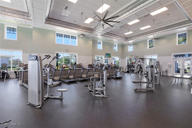 exercise room featuring ceiling fan and a high ceiling