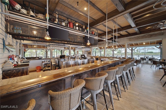 bar with plenty of natural light, beam ceiling, wooden ceiling, and decorative light fixtures