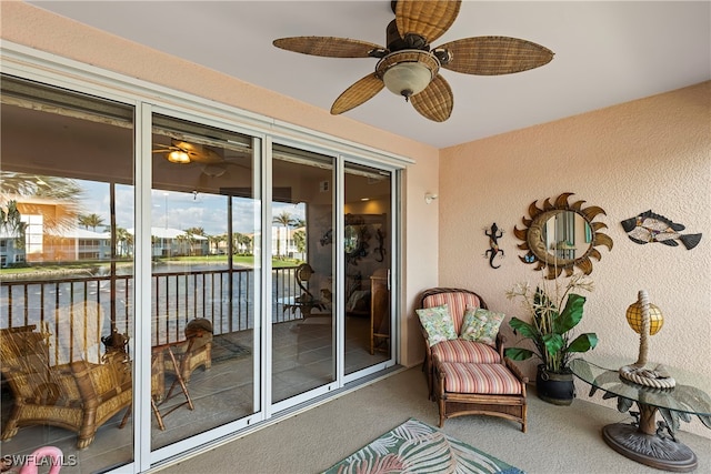 sunroom / solarium with a water view and ceiling fan