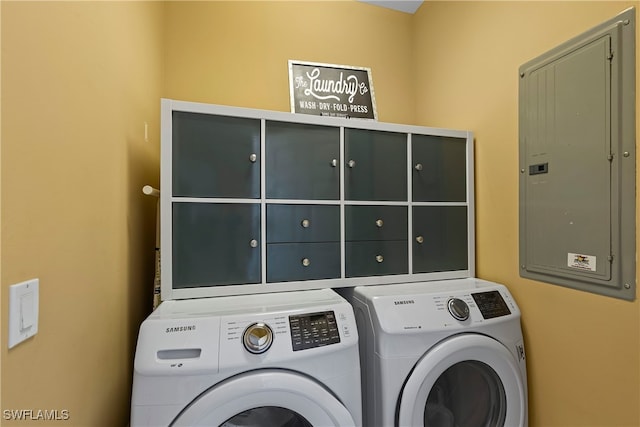 clothes washing area featuring electric panel, cabinets, and independent washer and dryer