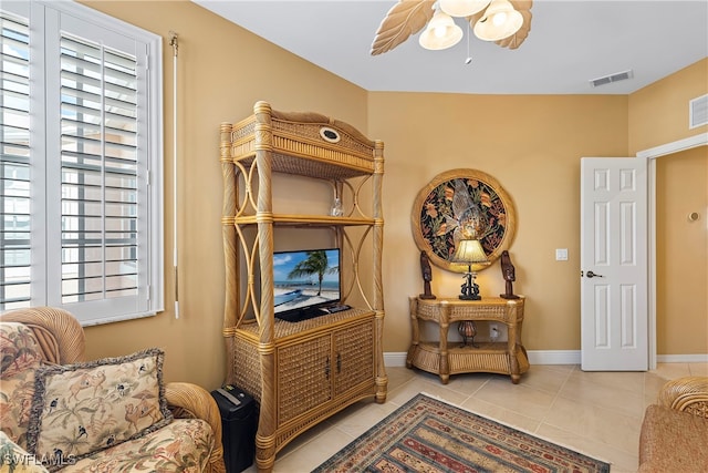 living area with light tile patterned floors and ceiling fan