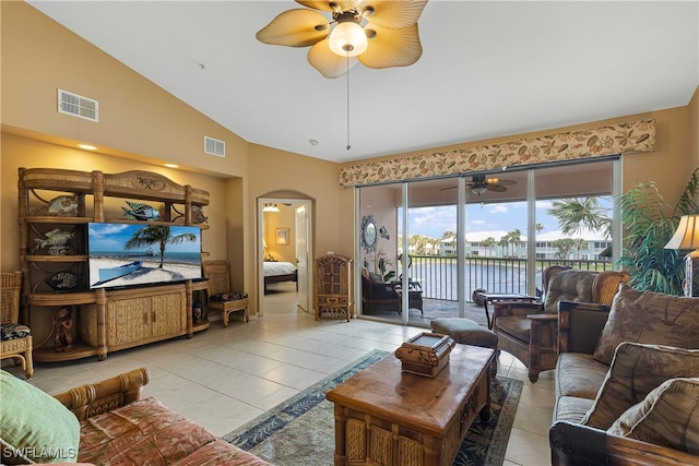 tiled living room with ceiling fan and high vaulted ceiling