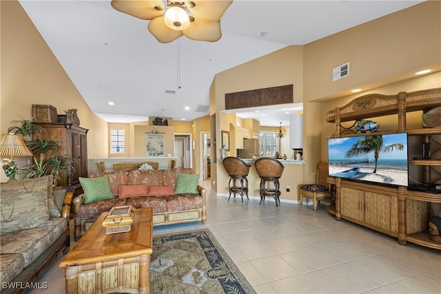 living room featuring light tile patterned floors, ceiling fan with notable chandelier, and high vaulted ceiling