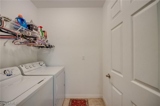 clothes washing area with washer and clothes dryer and light tile patterned floors