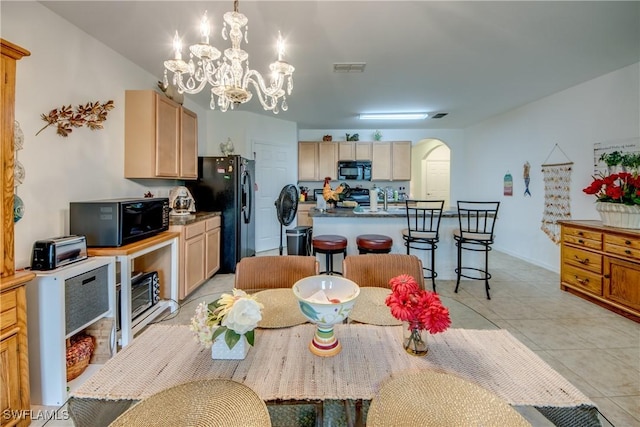 dining space featuring a chandelier, light tile patterned floors, and sink