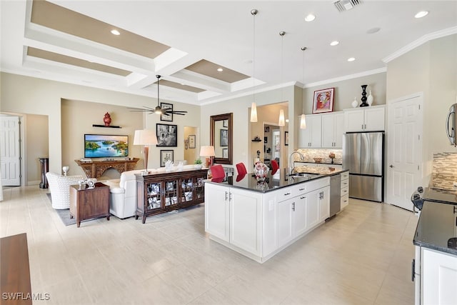 kitchen with appliances with stainless steel finishes, sink, pendant lighting, a center island with sink, and white cabinetry