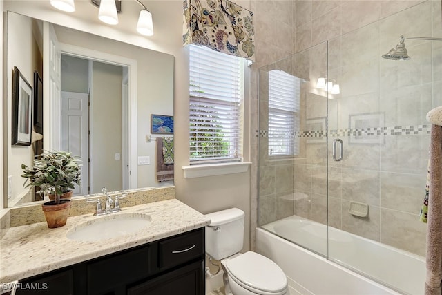 full bathroom with vanity, toilet, and enclosed tub / shower combo