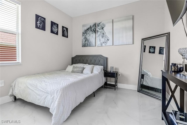 bedroom featuring marble finish floor and baseboards