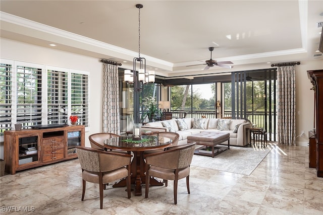 interior space featuring a tray ceiling, crown molding, and ceiling fan with notable chandelier