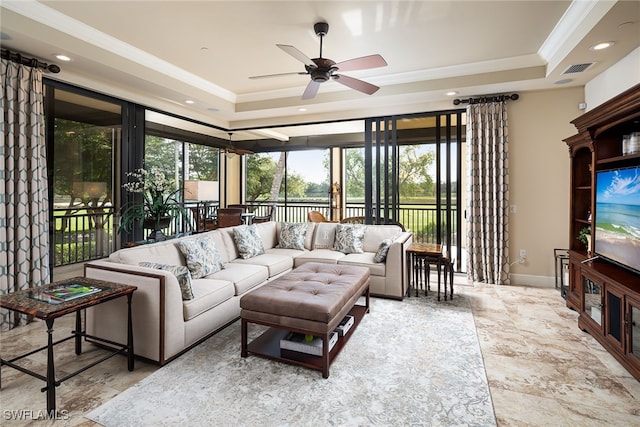 living room with a tray ceiling, ceiling fan, and ornamental molding