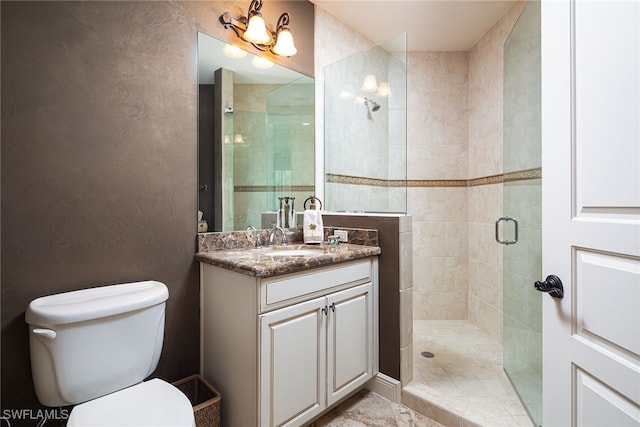 bathroom with vanity, toilet, and a shower with door