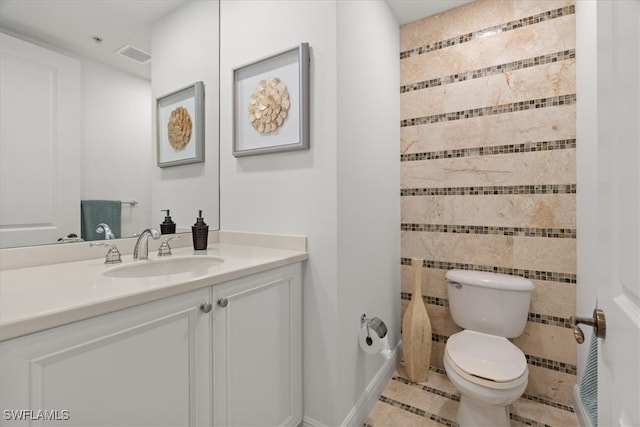 bathroom featuring tile patterned flooring, vanity, and toilet