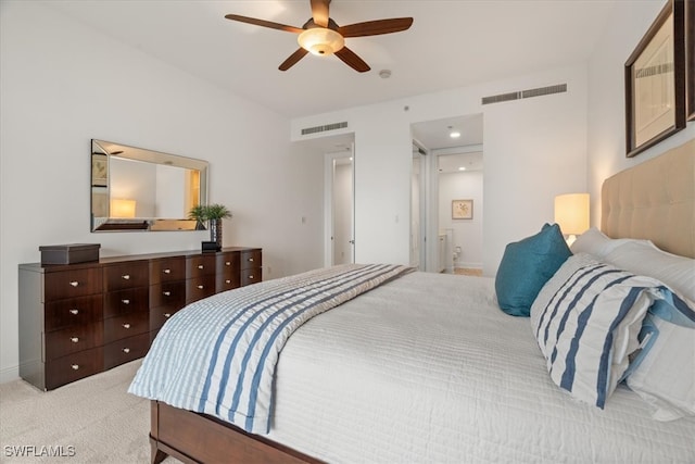 bedroom with connected bathroom, ceiling fan, and light colored carpet