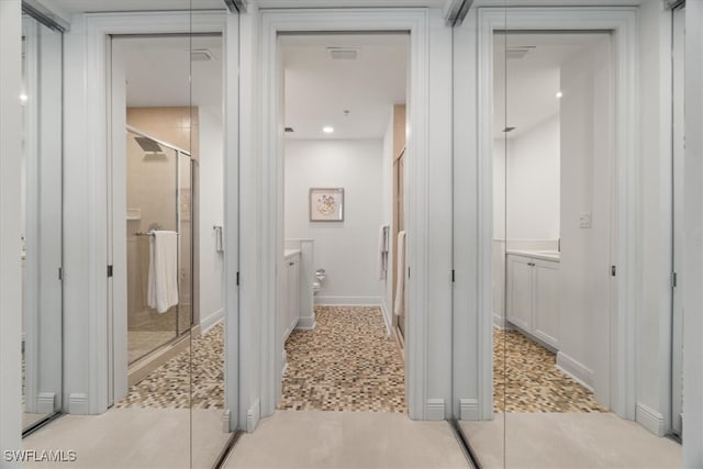 bathroom featuring vanity and a shower with door