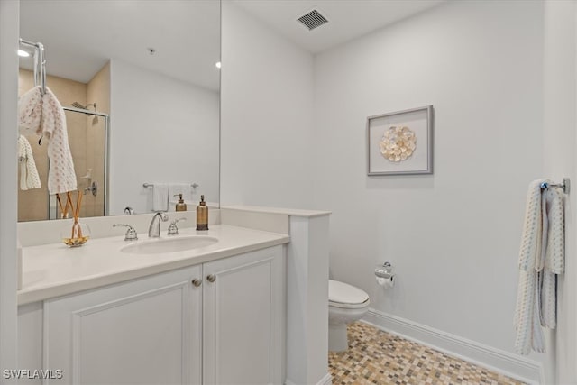 bathroom featuring tile patterned flooring, toilet, vanity, and walk in shower