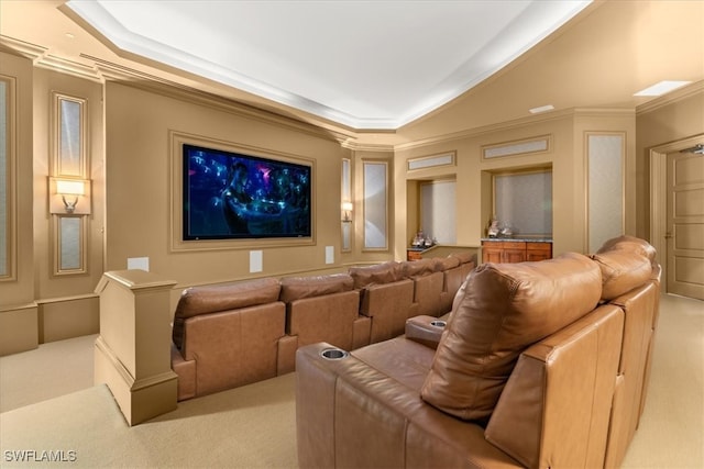 home theater with ornamental molding, light carpet, and a tray ceiling