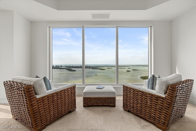 living area featuring a water view and a healthy amount of sunlight