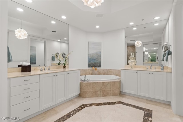 bathroom with vanity, a relaxing tiled tub, and tile patterned floors