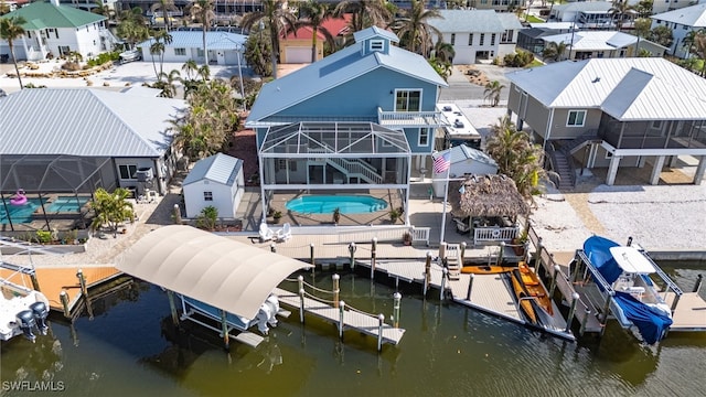 view of dock featuring glass enclosure, a balcony, a water view, and a patio