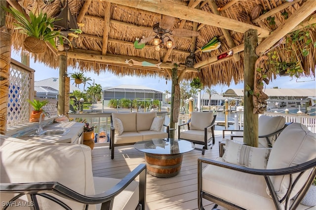 deck featuring a gazebo, a water view, and sink