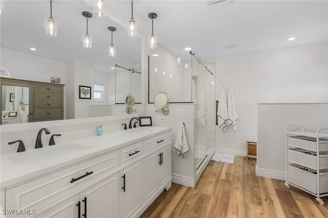 bathroom featuring hardwood / wood-style flooring, vanity, and a shower with door