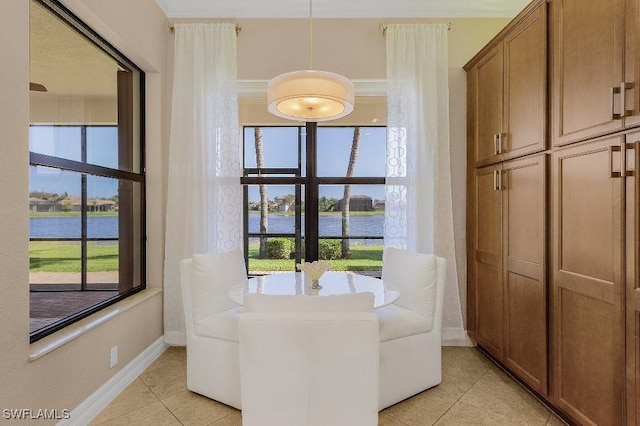 3741 Pleasant Springs Dr, Naples, FL 34119 - dining room featuring light tile patterned floors, baseboards, and a water view
