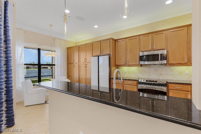 kitchen featuring sink, hanging light fixtures, stainless steel appliances, backsplash, and dark stone counters