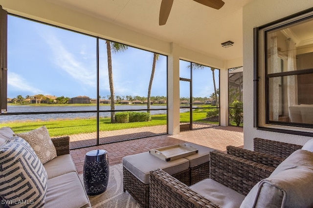 sunroom / solarium featuring ceiling fan and a water view