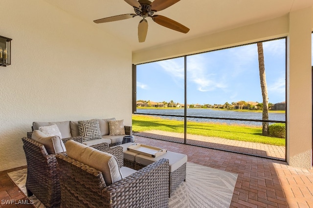 sunroom featuring a water view and ceiling fan