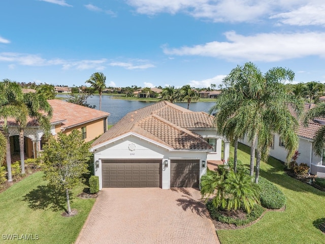 view of front of property featuring a water view, a garage, and a front lawn